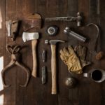 A display of tools on a wooden workbench.